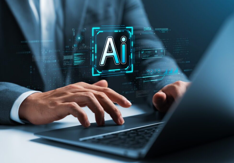 Person typing on laptop with AI hologram.